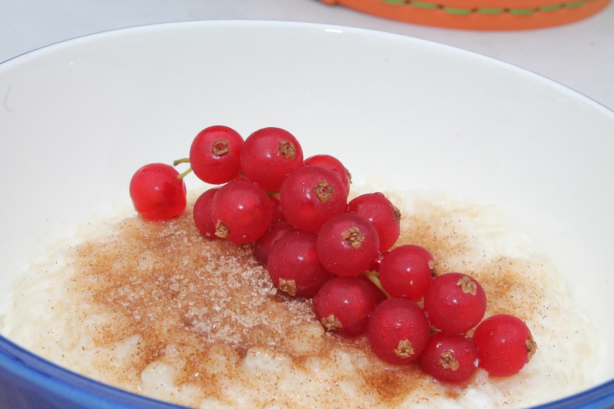 Prato de arroz doce com leite condensado e cerejas.