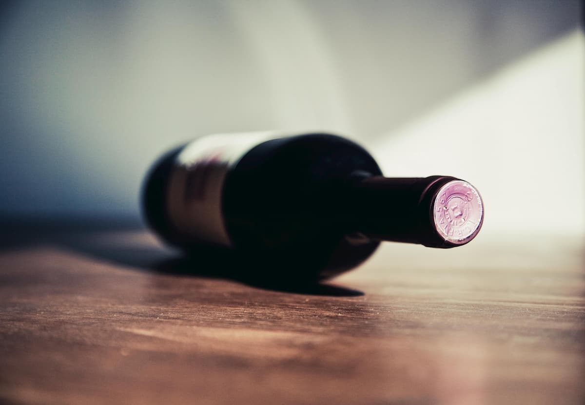 Uma garrafa de vinho deitada em uma mesa de madeira 
