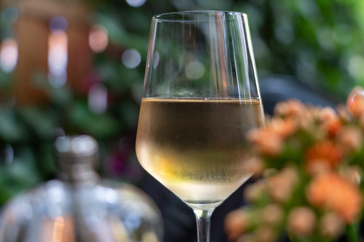 Taça transparente com vinho branco.