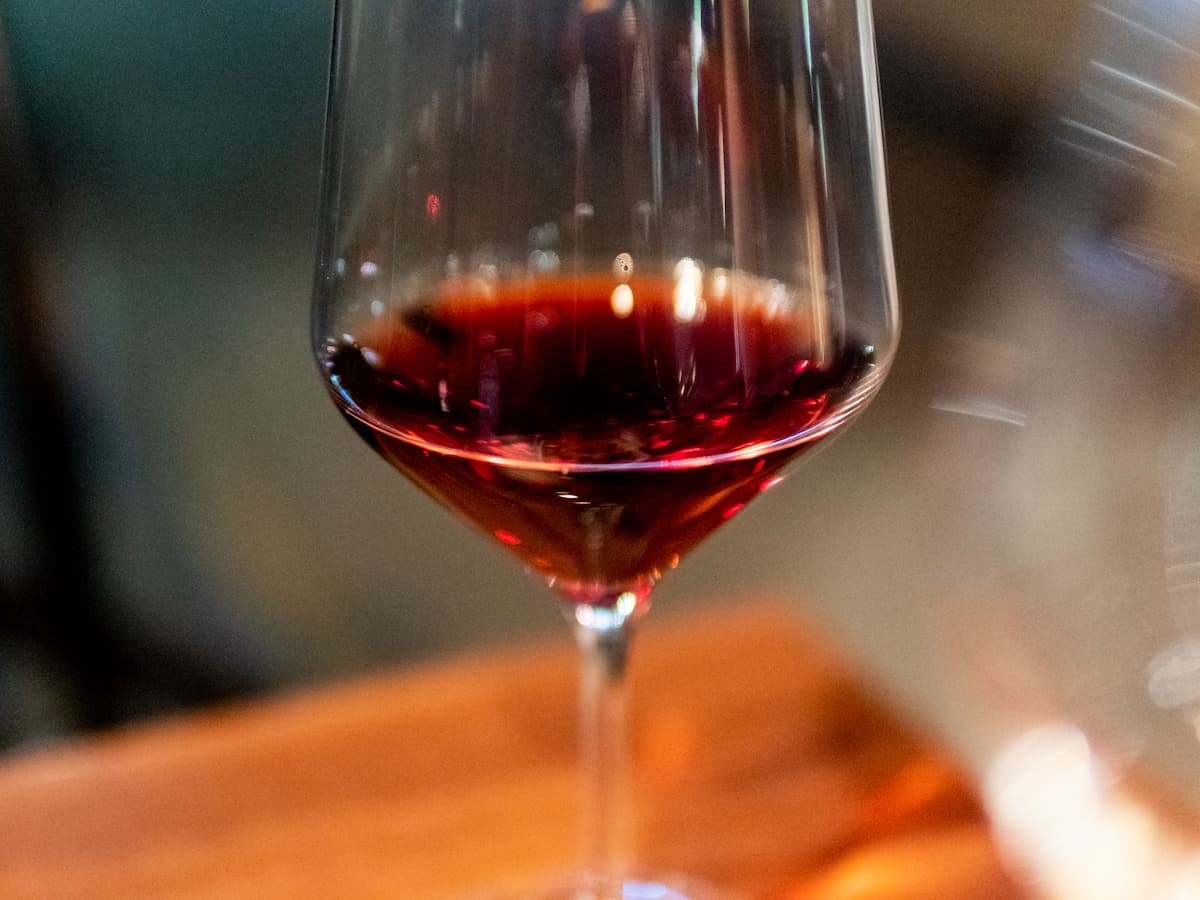 Taça de vinho tinto sobre uma mesa de madeira.