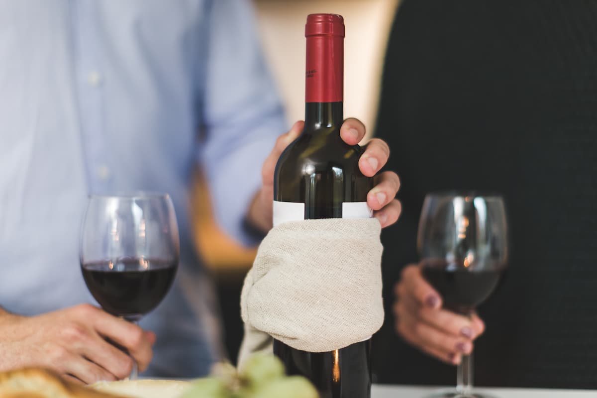 Duas pessoas em uma mesa tomando uma taça de vinho.