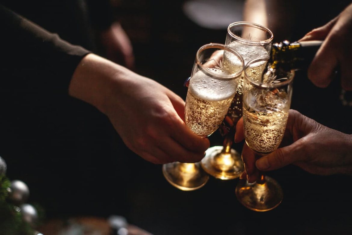 Pessoas brindando com ums taça de champagne