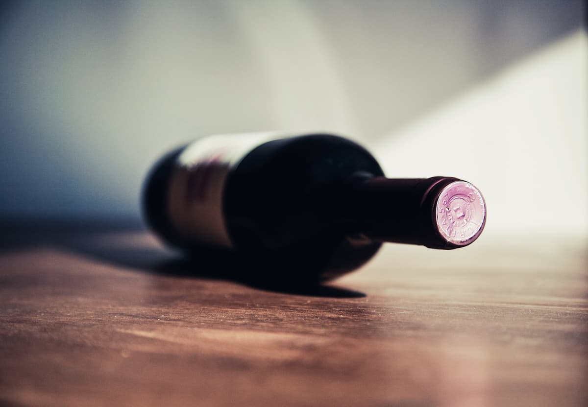 Uma foto de uma garrafa de vinho deitada na mesa 