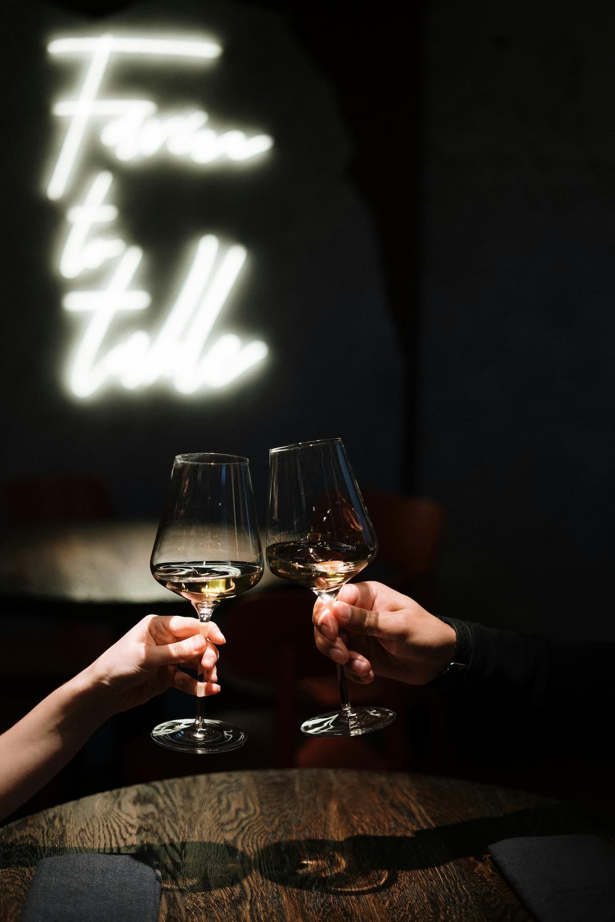 Duas pessoas brindando com uma taças de vinho 