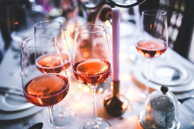 Imagens de algumas taças com vinho rosé.