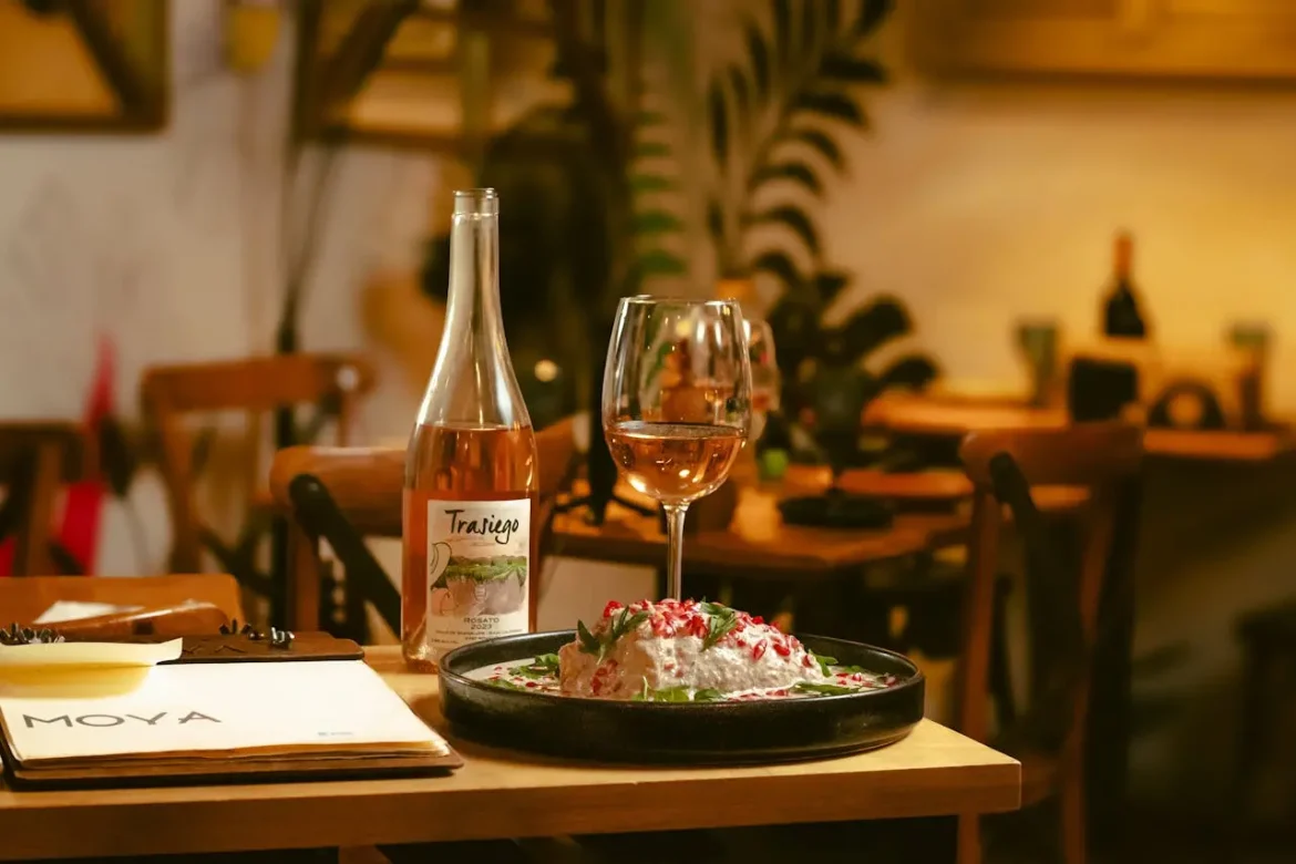 Imagem de um jantar e uma taça com vinho rosé